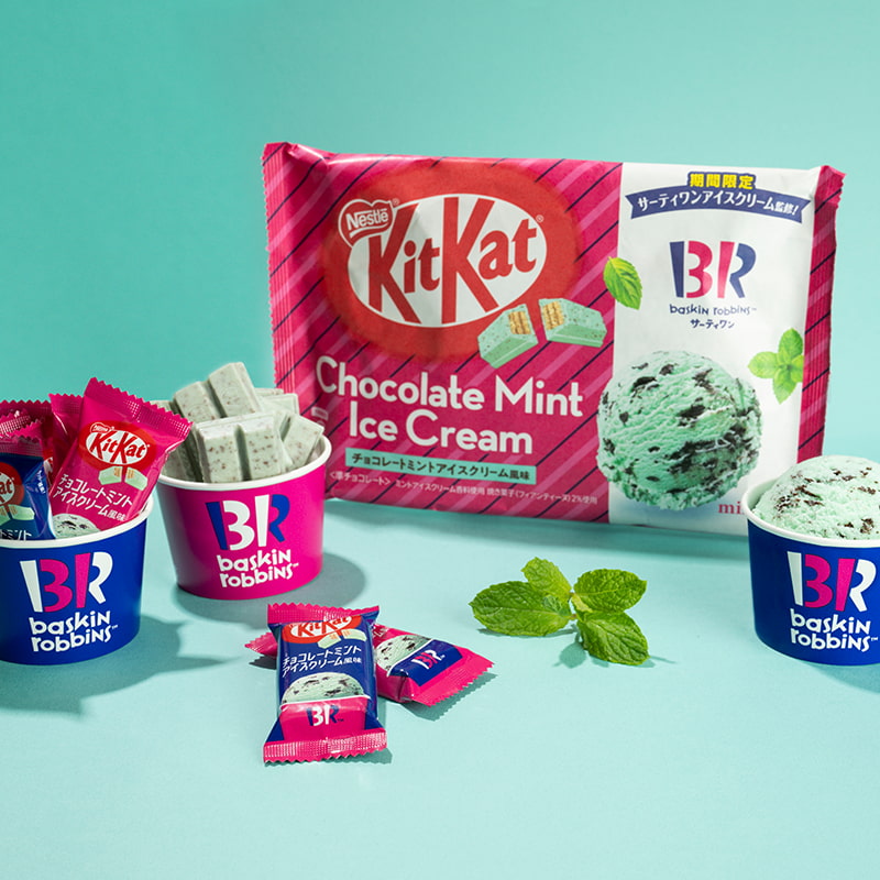 A pack of Japanese KitKats, chocolate mint ice cream flavor, surrounded by ice creams from Baskin Robbins